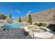Custom pool and spa with waterfall features, a fire pit, and landscaped surroundings at 2124 Pont National Dr, Henderson, NV 89044