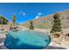 Backyard pool with rock features, a slide, and a cozy fire pit seating area at 2124 Pont National Dr, Henderson, NV 89044