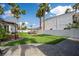 Lush backyard featuring synthetic grass, an outdoor seating area, and a stone paved patio at 219 Windsong Dr, Henderson, NV 89074