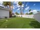 Artificial turf backyard with desert landscaping, palm trees and white brick privacy wall at 219 Windsong Dr, Henderson, NV 89074