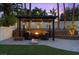 Relaxing backyard pergola with a fire pit, comfortable seating, and charming string lights at 219 Windsong Dr, Henderson, NV 89074