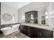 A bathroom features dual sinks, dark cabinetry, decorative tile, a glass shower, and a soaking tub at 219 Windsong Dr, Henderson, NV 89074