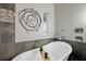 A bathroom features dark tile, neutral walls, and a soaking tub with a hand-held shower at 219 Windsong Dr, Henderson, NV 89074