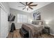 Comfortable bedroom with ceiling fan, wood-look floors, a window, and a wall-mounted television at 219 Windsong Dr, Henderson, NV 89074