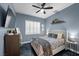 Cozy bedroom with blue accent wall, window with shutters, and dark flooring at 219 Windsong Dr, Henderson, NV 89074