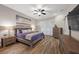 A bedroom features hardwood floors, neutral walls, modern decor, ceiling fan, and plantation shutters at 219 Windsong Dr, Henderson, NV 89074