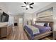 A bedroom features hardwood floors, neutral walls, modern decor, ceiling fan, and access to an ensuite at 219 Windsong Dr, Henderson, NV 89074