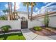Desert home with a walled front yard, landscaped with green plants and an ornate gate at 219 Windsong Dr, Henderson, NV 89074