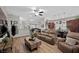 Open-concept living room next to the kitchen featuring modern furniture and decor, wood-look floors, and abundant natural light at 219 Windsong Dr, Henderson, NV 89074