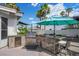 Outdoor kitchen with stainless steel grill, under-counter refrigerator, and bar with seating, perfect for entertaining at 219 Windsong Dr, Henderson, NV 89074
