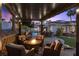 Relaxing covered patio with a fire pit and comfortable seating, overlooking the pool and backyard at 219 Windsong Dr, Henderson, NV 89074