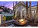 Cozy outdoor patio area featuring a fire pit, comfortable seating, and mature landscaping, creating a relaxing atmosphere at 219 Windsong Dr, Henderson, NV 89074
