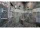A glass shower features river rock flooring, multiple shower heads, and decorative tile at 219 Windsong Dr, Henderson, NV 89074