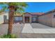 Exterior showcasing desert landscaping, a tile roof, and a two-car garage with a large palm tree at 2711 Briarcliff Ave, Henderson, NV 89074