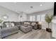 Open living room with a large gray sectional couch, an eye-catching mirror, and lots of natural light at 2711 Briarcliff Ave, Henderson, NV 89074