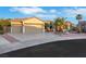 Well-maintained single-story home with a three-car garage, desert landscaping, and palm trees at 2873 Knoxville Ct, Henderson, NV 89052