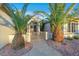 Charming home exterior featuring lush palm trees, desert landscaping, and a gated entrance at 2873 Knoxville Ct, Henderson, NV 89052