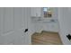 Laundry room with white cabinets, granite countertops, and wood floors at 2873 Knoxville Ct, Henderson, NV 89052