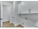 Bright laundry room with white cabinets and wood flooring at 2873 Knoxville Ct, Henderson, NV 89052