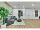 Bright living room with a gray velvet couch, area rug, and luxury vinyl plank flooring at 2873 Knoxville Ct, Henderson, NV 89052