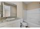 Bathroom with granite counters, framed mirror, and white tiled shower and tub at 3 Hilltop Crest St, Henderson, NV 89011