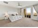 Spacious bedroom with large bed, ceiling fan, and sliding glass door leading to balcony at 3 Hilltop Crest St, Henderson, NV 89011