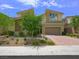 Landscaped front yard of a two-story home showing curb appeal with a wide driveway and desert accents at 3 Hilltop Crest St, Henderson, NV 89011