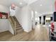 Bright hallway leading to open-concept living area featuring wood-look tile flooring and modern staircase at 3 Hilltop Crest St, Henderson, NV 89011