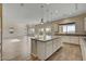 Spacious kitchen featuring a large island with granite countertops, ample cabinet space, and wood-look tile flooring at 3 Hilltop Crest St, Henderson, NV 89011