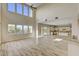 Bright, airy living room with soaring ceilings, large windows, wood-look tile flooring, and seamless kitchen access at 3 Hilltop Crest St, Henderson, NV 89011