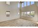 Spacious living area with tall ceilings, large windows offering views, and modern wood-look tile flooring throughout at 3 Hilltop Crest St, Henderson, NV 89011