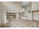 Open-concept living space featuring wood-look tile flooring, access to the kitchen, and modern staircase at 3 Hilltop Crest St, Henderson, NV 89011