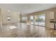Open-concept living space with wood-look tile flooring leading to a sliding glass door to the backyard and pool at 3 Hilltop Crest St, Henderson, NV 89011