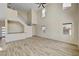 Spacious living room with wood-look tile flooring, high ceilings, and plenty of natural light from multiple windows at 3 Hilltop Crest St, Henderson, NV 89011