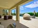 Covered patio with seating area overlooking a landscaped backyard and luxurious pool at 3 Hilltop Crest St, Henderson, NV 89011