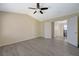 Open bedroom with light gray floors, vaulted ceilings, ceiling fan, and open doors to the hallway at 3034 Scenic Valley Way, Henderson, NV 89052