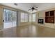 Cozy living room showcasing a fireplace, ceiling fan, and sliding door to the backyard pool at 3034 Scenic Valley Way, Henderson, NV 89052
