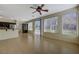 Open-concept living area with kitchen access, a ceiling fan, and sliding glass doors at 3034 Scenic Valley Way, Henderson, NV 89052