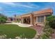 Beautiful backyard featuring manicured lawn, lush landscaping, and a covered patio for outdoor enjoyment at 3040 Hidden Treasure Dr, Las Vegas, NV 89134