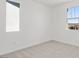 A simple bedroom with light carpet, white walls, and two windows for natural light at 328 Taylor St, Henderson, NV 89015