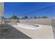A view of an empty inground swimming pool in a backyard with mature plants, ready for summer fun at 3382 Berwyck St, Las Vegas, NV 89121