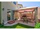 Inviting backyard featuring a covered patio, perfect for outdoor dining and entertaining, complemented by artificial turf at 3404 Brayton Mist Dr, North Las Vegas, NV 89081