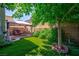 Lush backyard with artificial turf and mature trees, providing a serene outdoor space with covered patio at 3404 Brayton Mist Dr, North Las Vegas, NV 89081