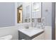 Bathroom featuring a sink with white countertop and cabinet, a mirrored cabinet, and gray backsplash tile at 3404 Brayton Mist Dr, North Las Vegas, NV 89081