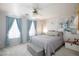 Cozy bedroom with a floral accent wall, complemented by soft blue curtains and a comfortable, neutral-toned bed at 3404 Brayton Mist Dr, North Las Vegas, NV 89081