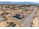 Aerial view of a desert home with solar panels, an expansive lot, landscaping, and views of the surrounding desert landscape at 3430 Flagstone Ct, Pahrump, NV 89048