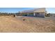Expansive backyard featuring desert landscaping, open space and a covered patio ideal for outdoor activities and relaxation at 3430 Flagstone Ct, Pahrump, NV 89048