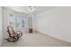 Bright bedroom with neutral carpet, bay window, ceiling fan and a cozy rocking chair at 3430 Flagstone Ct, Pahrump, NV 89048