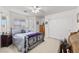 Carpeted bedroom featuring natural light, ceiling fan, and a comfortable wrought iron bed frame at 3430 Flagstone Ct, Pahrump, NV 89048