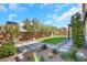 Landscaped backyard with artificial lawn, desert plants, trees, and hardscape pavers offering a serene outdoor space at 3512 Portiani Dr, Las Vegas, NV 89141